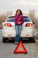 Woman calls to a service standing by a white car.