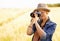 Woman, camera and photography with safari, vacation and holiday with wheat field and plants. Nature, photographer and