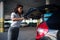 Woman can`t close trunk with suitcases, parking