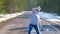 Woman in cap dancing in forest on country road in vr googles waving hands.