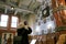 A woman captures a moment with her smartphone at the Kazinczy Street Synagogue in Budapest, blending modern technology with