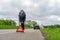 Woman with car breakdown puts the warning triangle behind the car