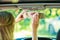 Woman in car cleaning rear mirror