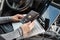 Woman in the car with laptop and germany passport. Travel concept.