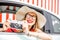Woman in the car on red wall background