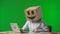 Woman in cardboard box with smiling emoji on her head on green background of studio. Employee checks data in documents