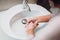 woman carefully washing hands with soap and sanitiser in bathroom. top view, details of hygiene, disinfecting hands