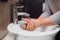 Woman carefully washing hands with soap and sanitiser at home during worldwide coronavirus pandemic