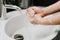 Woman carefully washing hands with soap and sanitiser at home during worldwide coronavirus pandemic