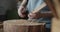 Woman carpenter carves piece of wood making a spoon close-up