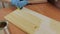 A woman carpenter, designer, decorator, works in a workshop, covers the wooden surface with oil.