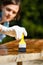 Woman carpenter inspecting freshly painted wood