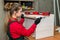 Woman carpenter measure wooden plank in workshop