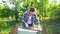 Woman carpenter processing wooden plank with metal brush in garden