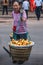 Woman carries 2 baskets of fruits on shoulder pole, Chongqing, China