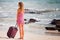 Woman carries your luggage at sandy beach