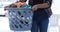 Woman carrying clothes in laundry basket at laundromat 4k