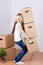 Woman Carrying Heavy Cardboard Boxes In House
