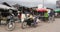 woman carrying plastic bags filled with vegetables and fresh meat on his moped