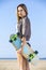 Woman Carrying Skateboard On Beach