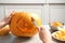 Woman carving pumpkin head Jack lantern for Halloween at light table indoors