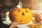 woman carving pumpkin into jack-o-lantern for halloween holiday decoration at home