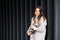 Woman in casual jacket hugging her favorite fluffy trained purebred Jack Russell Terrier dog dressed in suit for dogs near wall in