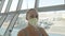 Woman caucasian at airport with wearing protective medical mask on head against the background of the plane. Coronavirus