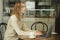 woman Caucasian working on a laptop behind the glass in a cafe. Concept teleworking and remote work.