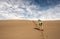 Woman Cautiously Hikes Down Steep Dune