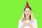 A Woman Celebrates Her Birthday with a Cupcake and Candle with a Party Hat on Green Screen