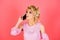 Woman with cell phone. Young woman over isolated pink background with phone. Young blonde woman with smart phone.