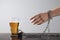 Woman chained to glass of beer at table against white background, closeup. Alcohol addiction