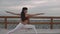 Woman is changing position of yoga asanas on class outdoors near sea