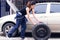 A woman is changing tyre of car for automotive maintenance service