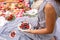 Woman in checkered stylish dress take berry from berries plate. Outdoor picnic