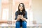 Woman Checking Email On Modern Cellular While Sitting At Corridor