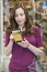 Woman Checking Labelling On Box In Supermarket