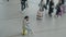 Woman checking phone in airport, waiting for a flight. Portrait of young businesswoman sitting on a luggage in heart of