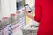 Woman Checking Shopping List On Smartphone In Supermarket