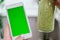 Woman checking smartphone with chroma key green screen drinking vegan smoothie drink detox. Woman doing yoga exercises