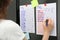 Woman checking to do list on refrigerator door in kitchen