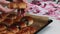 A woman checks the quality of baked buns. A baking sheet with baked buns. Bunks with different fillings. Close-up