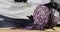 Woman chef is cooking cutting fresh red cabbage on wooden board, hands closeup.