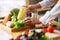 A woman chef holding and picking a fresh corn from a vegetables tray