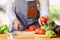 A woman chef holding and picking a fresh tomato from a vegetables tray