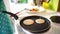 Woman chef pouring pancake batter on a frying pan.