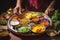 Woman chef prepares traditional vegetarian Indian thali