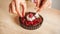 Woman chef preparing chocolate cake with whipped cream and raspberry