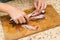 A woman chef slices a fish mackrel on a wooden Board